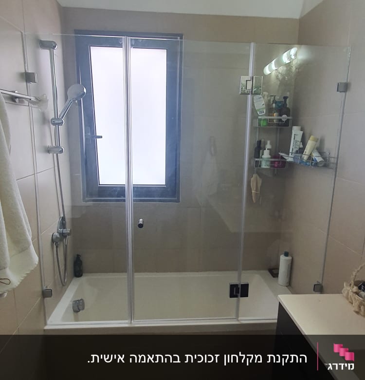 מקלחת עם דלת זכוכית, מדף עם מוצרי טיפוח